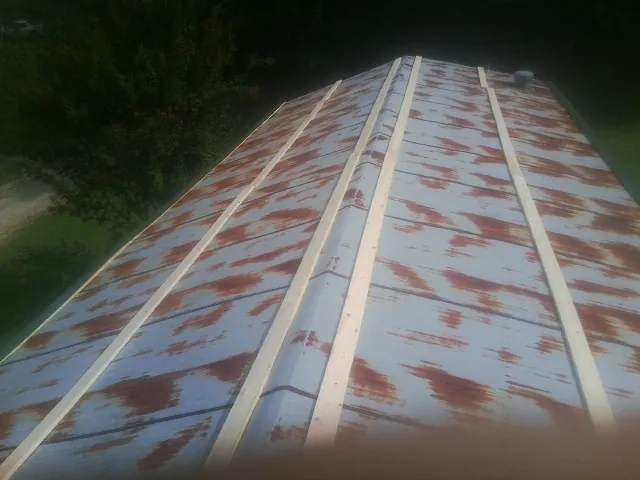 Rusted metal roof panels with new wood purlins before replacement — Storm Damage Roof Repair in Tussy by Roofing Brothers