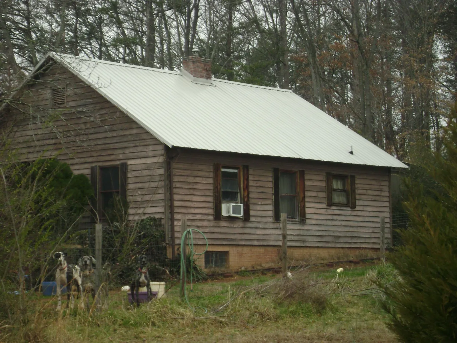 White metal roof on an old wood sided farmhouse, from a Metal Roof Installation job in Tussy